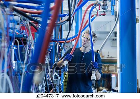 Factory technician inspecting network cables View Large Photo Image Stock Photo - Factory technician inspecting network cables. Fotosearch