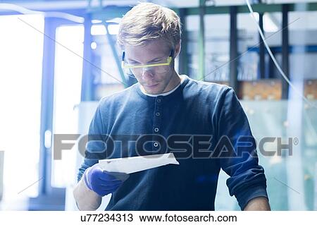 Factory technician reading leaflet in factory View Large Photo Image Stock Image - Factory technician reading leaflet in factory. Fotosearch