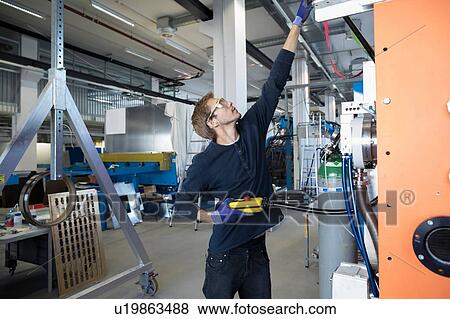 Stock Photo - Factory technician testing control panel. Fotosearch
