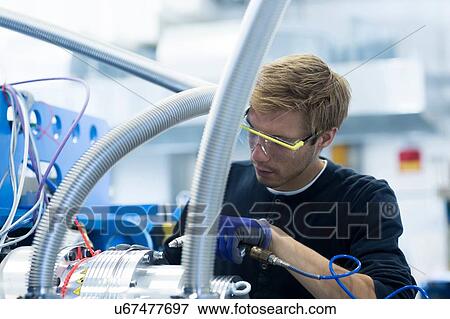 Stock Photo - Factory technician testing network cables. Fotosearch