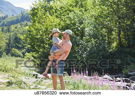 Stock Image - Father and daughter beside stream, Saut Deth Pish, Valle de Aran, Spain. Fotosearch