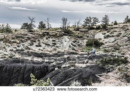 Stock Image - Father and son hiking in rugged landscape, Bridger, Montana, USA. Fotosearch