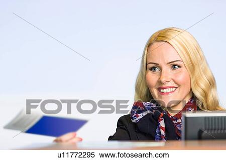 Female check in desk staff handing over boarding pass View Large Photo Image Stock Photography - Female check in desk staff handing over boarding pass. Fotosearch