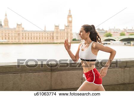Picture - Female runner running along Southbank, London, UK. Fotosearch