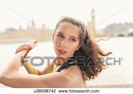Stock Image - Female runner warming up on Southbank, London, UK. Fotosearch