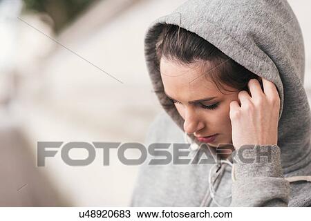 Female runner wearing grey hoody listening to earphone music View Large Photo Image Stock Image - Female runner wearing grey hoody listening to earphone music. Fotosearch