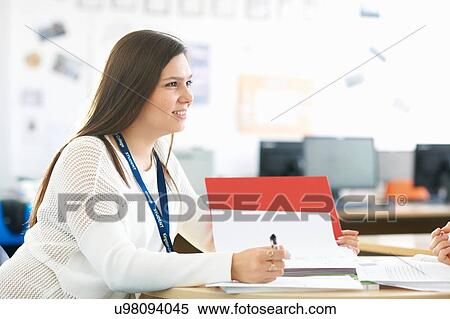 Stock Photography - Female student having tutorial in class. Fotosearch