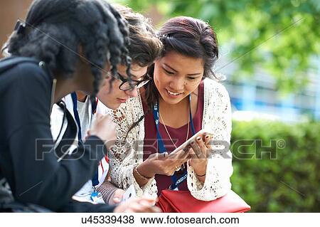 Female students on college campus reading smartphone texts View Large Photo Image Stock Photo - Female students on college campus reading smartphone texts. Fotosearch
