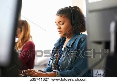 Stock Photo - Female students typing on desktop computer in classroom. Fotosearch