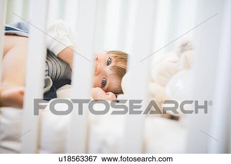 Female toddler lying in crib looking at camera View Large Photo Image Stock Photo - Female toddler lying in crib looking at camera. Fotosearch