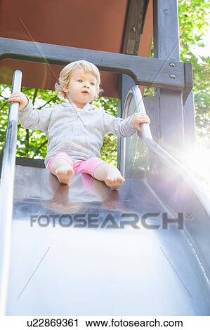 Female toddler playing on park slide View Large Photo Image Stock Image - Female toddler playing on park slide. Fotosearch