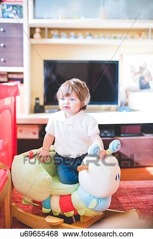 Female toddler playing with rocking toy in living room View Large Photo Image Stock Photo - Female toddler playing with rocking toy in living room. Fotosearch