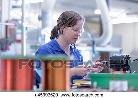 Female worker assembling electromagnetic coils in electronics factory View Large Photo Image Stock Image - Female worker assembling electromagnetic coils in electronics factory. Fotosearch