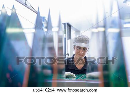 Female worker inspecting circuit boards in circuit board factory View Large Photo Image Picture - Female worker inspecting circuit boards in circuit board factory. Fotosearch