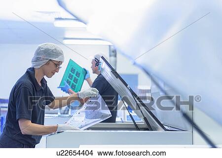 Picture - Female worker printing boards in circuit board factory. Fotosearch