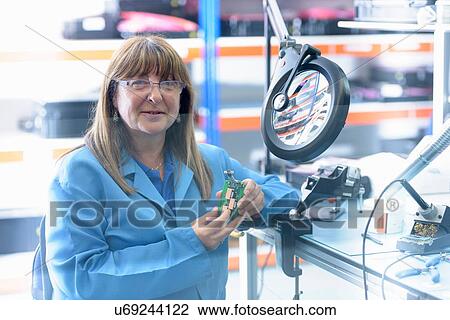 Female worker soldering electronic parts in clean room in electronics factory View Large Photo Image Stock Image - Female worker soldering electronic parts in clean room in electronics factory. Fotosearch