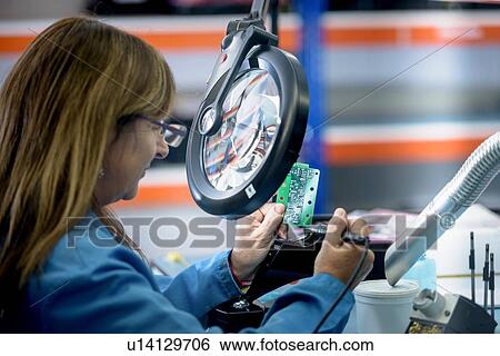 Female worker soldering electronic parts in clean room in electronics factory View Large Photo Image Stock Photograph - Female worker soldering electronic parts in clean room in electronics factory. Fotosearch