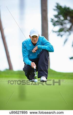 Front view of golfer crouching down considering strategy View Large Photo Image Stock Photography - Front view of golfer crouching down considering strategy. Fotosearch