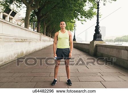 Full length portrait of male runner holding water bottle View Large Photo Image Stock Photograph - Full length portrait of male runner holding water bottle. Fotosearch