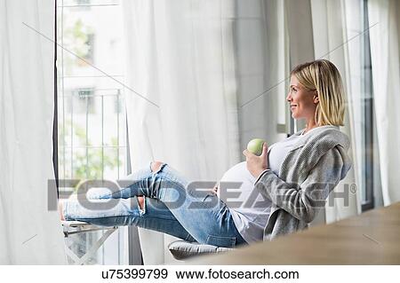 Full term pregnancy young woman eating apple View Large Photo Image Stock Photo - Full term pregnancy young woman eating apple. Fotosearch