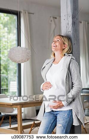 Full term pregnancy young woman in kitchen holding her stomach View Large Photo Image Stock Image - Full term pregnancy young woman in kitchen holding her stomach. Fotosearch