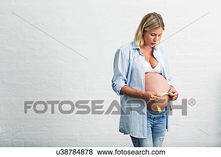 Full term pregnancy young woman measuring stomach View Large Photo Image Stock Photo - Full term pregnancy young woman measuring stomach. Fotosearch