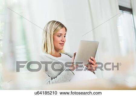 Full term pregnancy young woman using touchscreen on digital tablet View Large Photo Image Stock Image - Full term pregnancy young woman using touchscreen on digital tablet. Fotosearch