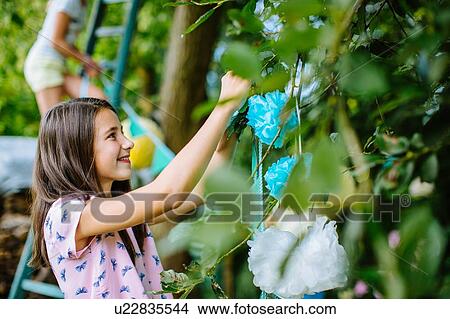 Picture - Girl decorating garden for summer party. Fotosearch