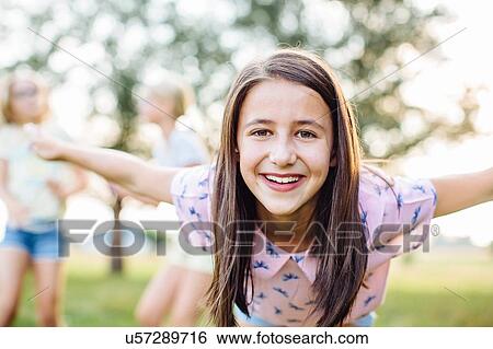 Girl smiling with outstretched arms in garden View Large Photo Image Stock Photograph - Girl smiling with outstretched arms in garden. Fotosearch