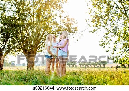 Girls chatting on field, Flanders, Belgium View Large Photo Image Picture - Girls chatting on field, Flanders, Belgium. Fotosearch