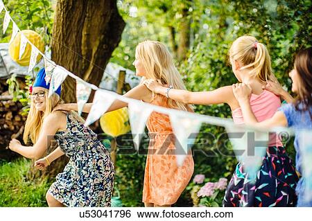 Stock Photograph - Girls dancing at summer garden party. Fotosearch