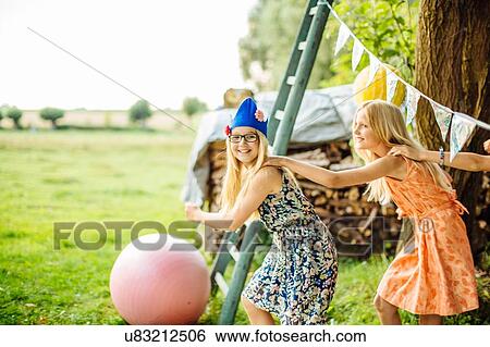 Stock Photograph - Girls dancing at summer garden party. Fotosearch