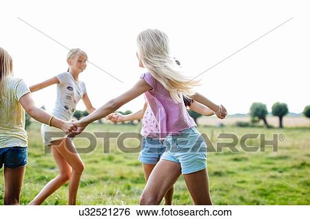 Stock Photograph - Girls dancing in ring on field, Flanders, Belgium. Fotosearch