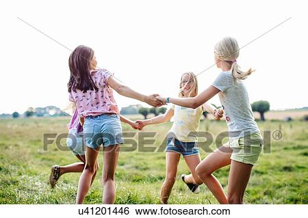 Girls dancing in ring on field, Flanders, Belgium View Large Photo Image Stock Photograph - Girls dancing in ring on field, Flanders, Belgium. Fotosearch