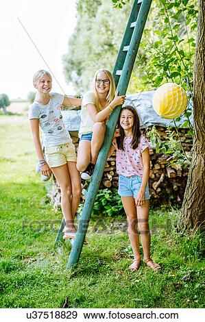 Stock Photo - Girls decorating garden for summer party. Fotosearch