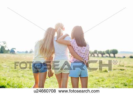 Stock Photo - Girls enjoying view in field, Flanders, Belgium. Fotosearch