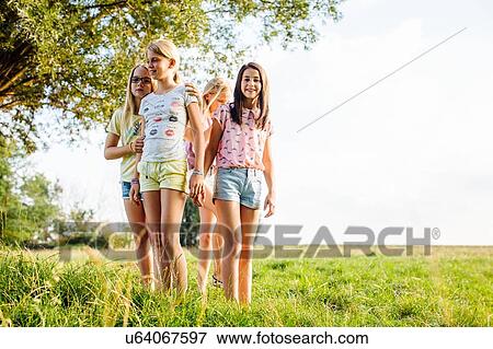 Stock Photo - Girls enjoying view in field, Flanders, Belgium. Fotosearch