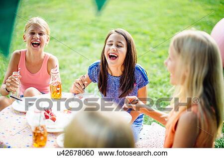 Stock Image - Girls having fun at summer garden party. Fotosearch