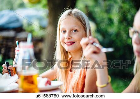Stock Image - Girls having fun at summer garden party. Fotosearch