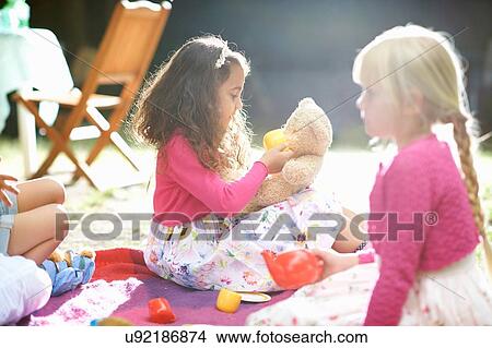 Girls playing picnics at garden birthday party View Large Photo Image Picture - Girls playing picnics at garden birthday party. Fotosearch
