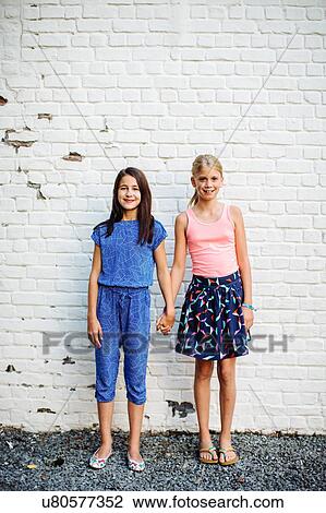 Girls posing against white wall View Large Photo Image Stock Image - Girls posing against white wall. Fotosearch