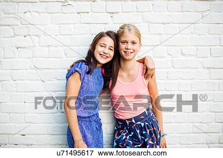 Girls posing against white wall View Large Photo Image Stock Photo - Girls posing against white wall. Fotosearch