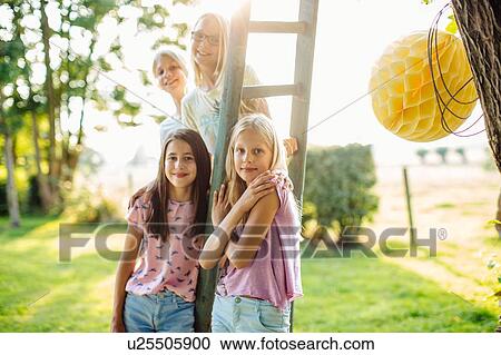 Girls posing by ladder at summer party View Large Photo Image Stock Image - Girls posing by ladder at summer party. Fotosearch