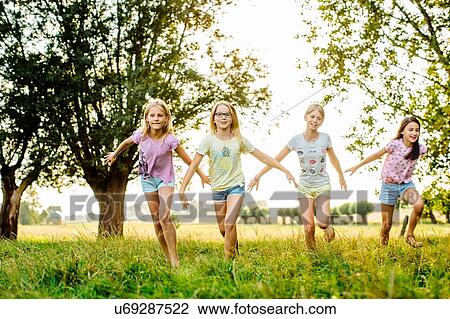 Girls running in line, on field, Flanders, Belgium View Large Photo Image Stock Image - Girls running in line, on field, Flanders, Belgium. Fotosearch
