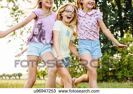 Girls running together on field, Flanders, Belgium View Large Photo Image Stock Image - Girls running together on field, Flanders, Belgium. Fotosearch