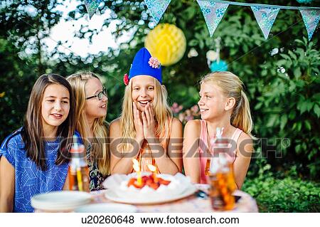 Girls with birthday cake at summer garden party View Large Photo Image Stock Photo - Girls with birthday cake at summer garden party. Fotosearch