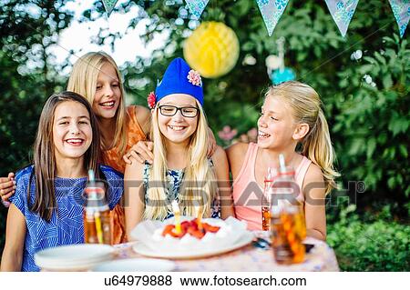 Girls with birthday cake at summer garden party View Large Photo Image Stock Photo - Girls with birthday cake at summer garden party. Fotosearch