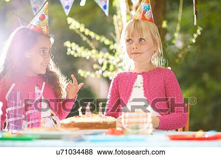 Girls with finger in birthday cake at garden birthday party View Large Photo Image Stock Photo - Girls with finger in birthday cake at garden birthday party. Fotosearch