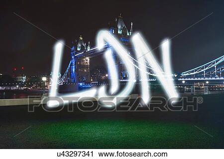 Stock Image - Glowing abbreviated London symbol in front of Tower Bridge at night. Fotosearch