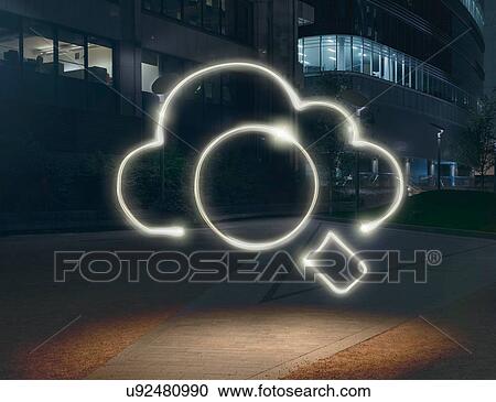 Stock Image - Glowing cloud symbol surrounding circle in city at night. Fotosearch